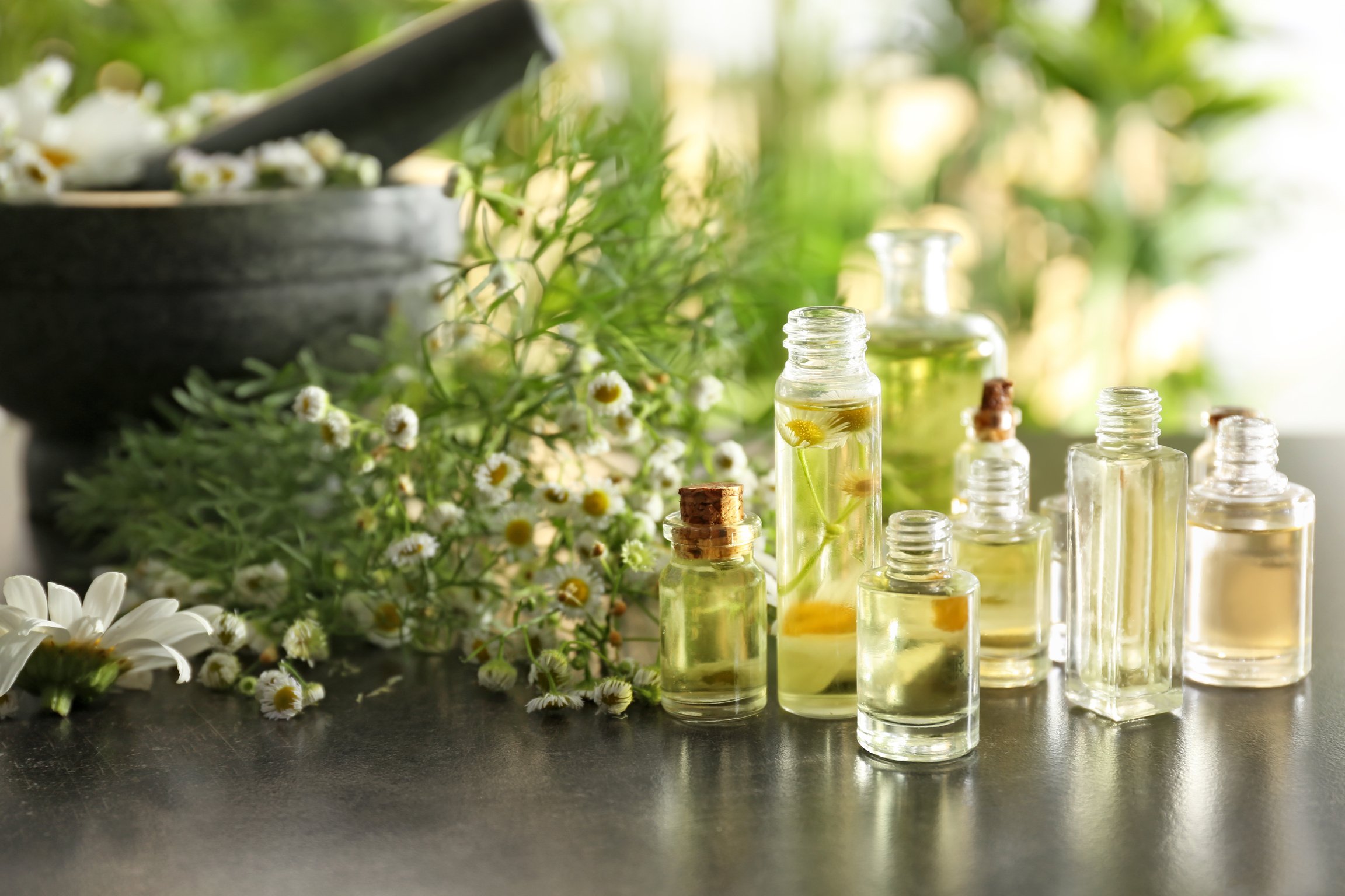 Bottles with Chamomile Essential Oil on Table